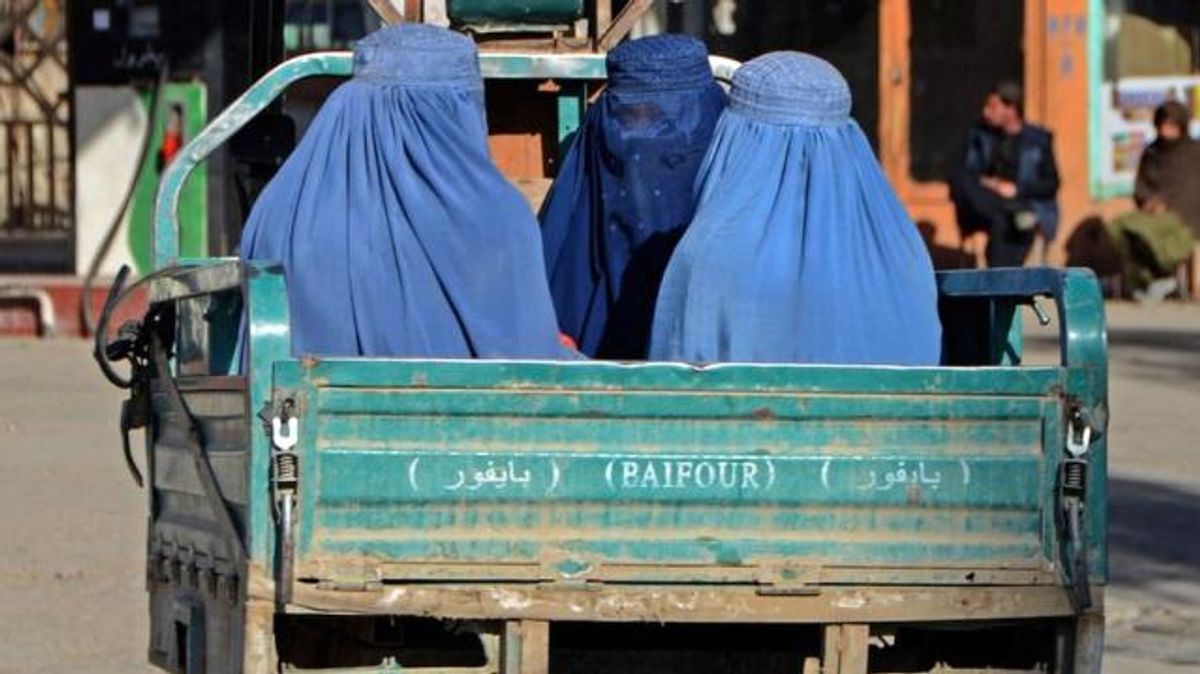 Afganistan'da kadınlar bir kamyonun arkasında oturuyor