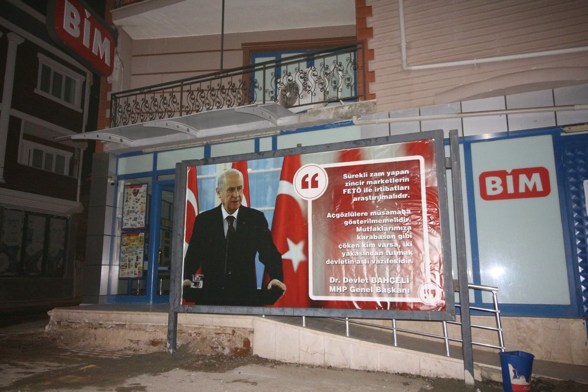 Bahçeli'den altınının basıldığı, Bim'in önünde koyulan pano