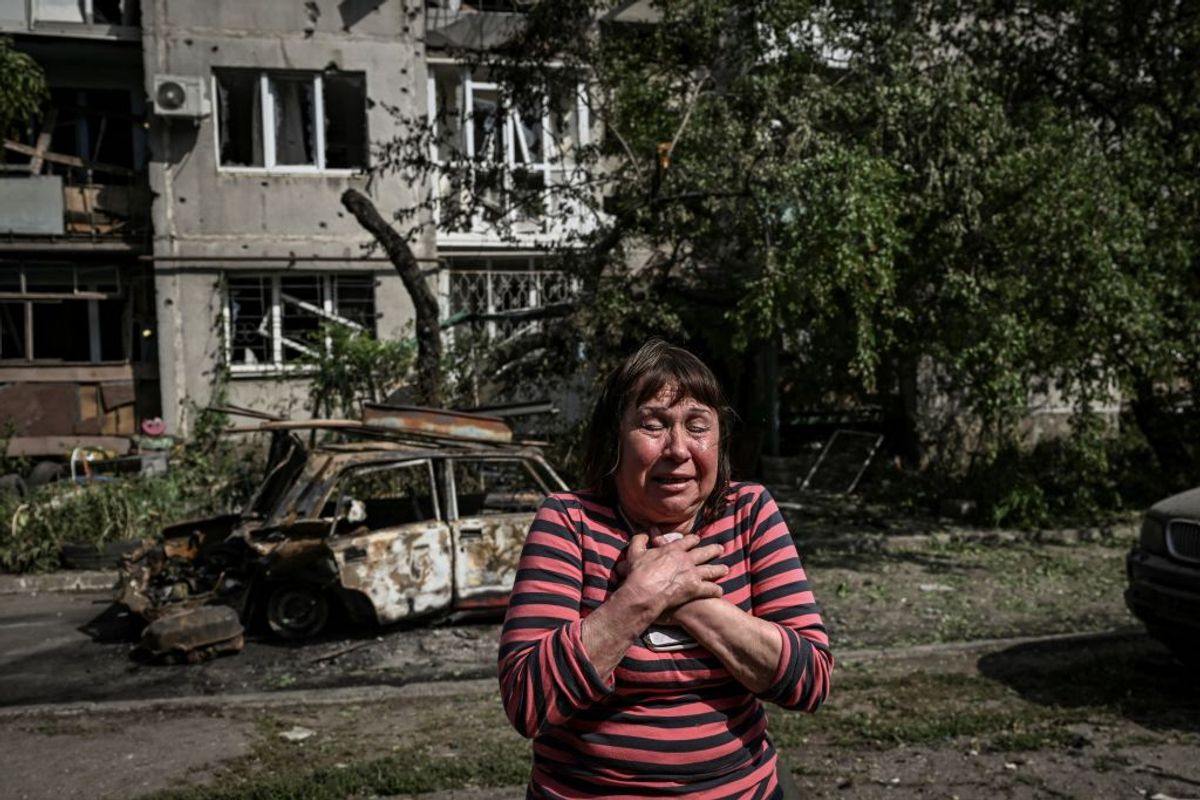 Donbass bölgesinde yıkılmış bir evin önünde ağlayan bir kadın