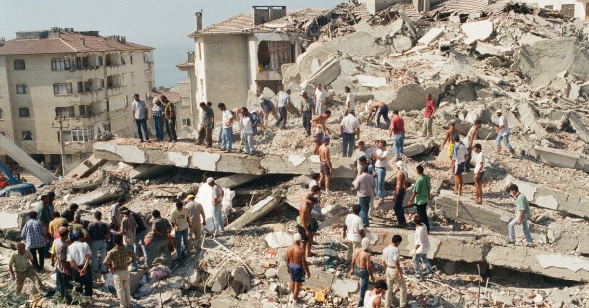 Yalova'da 1999 depreminin ardından yaklaşık 40 kişi bir ev yıkıntısının üzerinde arama kurtarma çalışmalarına hazırlanıyor.