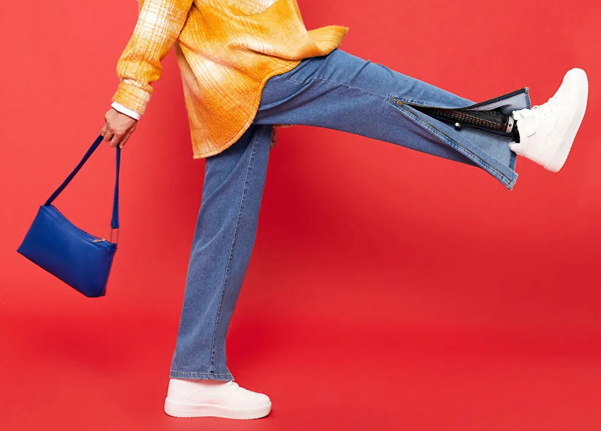Paça kısmında fermuar olan kot pantolon. pantolonun fermuarı açık ve modelin protez bacağı görünüyor.