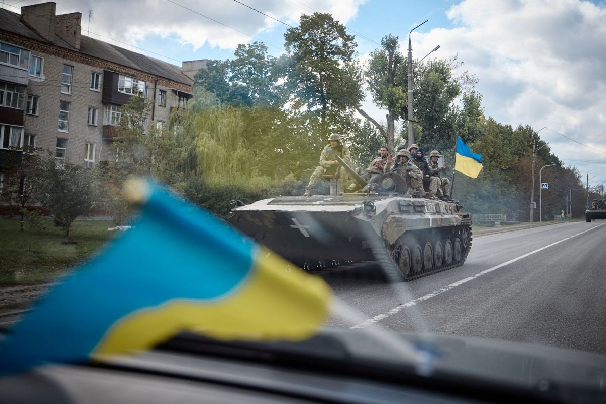 Ukrainian service members ride on an armoured fighting vehicle in the town of Kupiansk, recently liberated by the Armed Forces in Kharkiv region