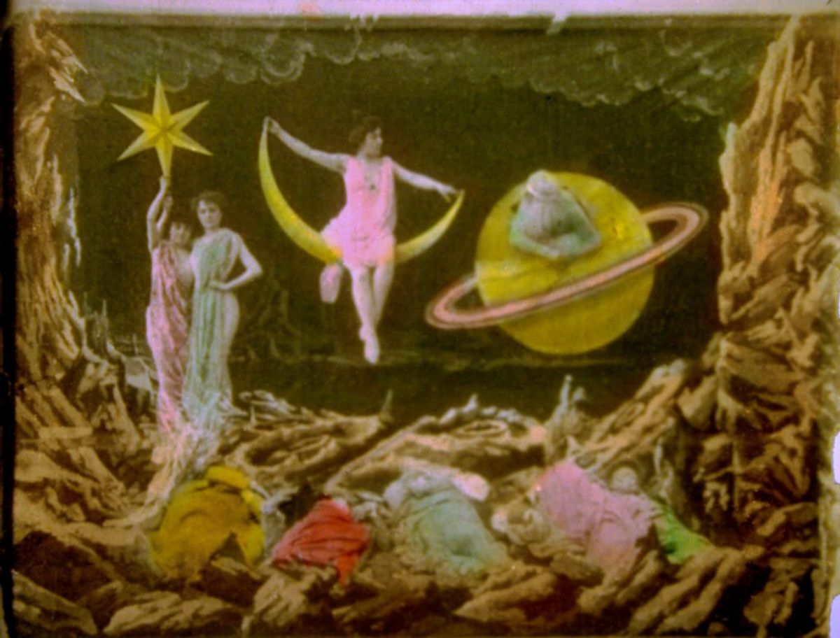 A Trip to the Moon'dan bir kare (1902) pastel kıyafetler giymiş üç kadın gezegenler etrafında görülüyor.